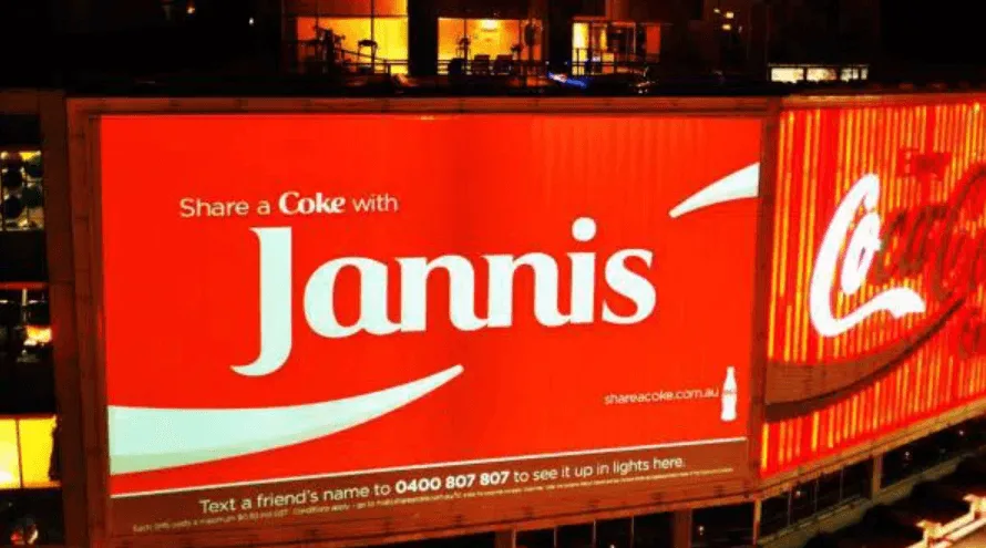 Cartel luminoso nocturno de la campaña Share a Coke de Coca-Cola con el nombre Jannis